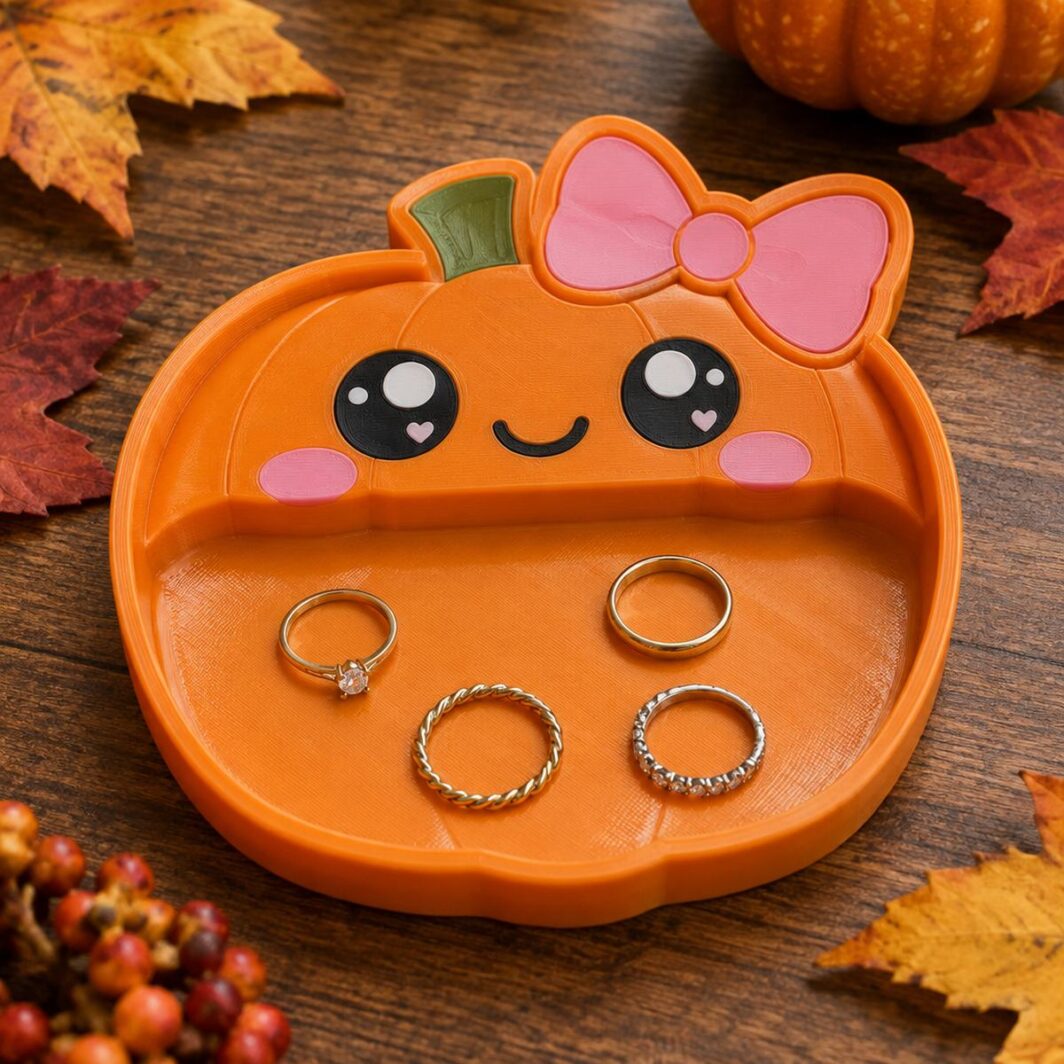 Bandeja con forma de calabaza kawaii naranja con ojos brillantes y lazo rosa con anillos dentro