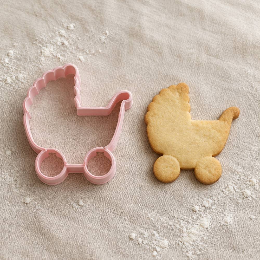 Cortador de galletas con forma de carrito junto a una galleta horneada con la misma forma