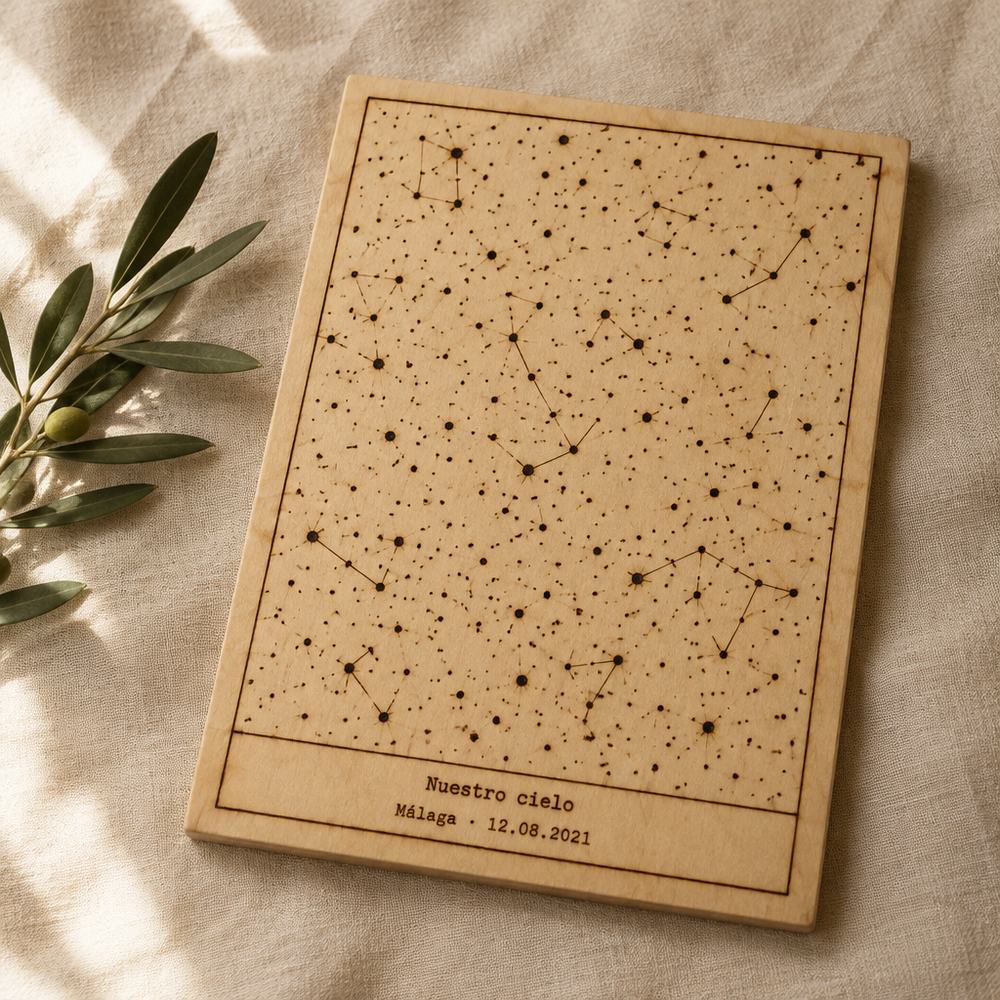 Cuadro A4 de madera con un mapa estelar rectangular pirograbado punto a punto y el texto «Nuestro cielo · Málaga · 12.08.2021»