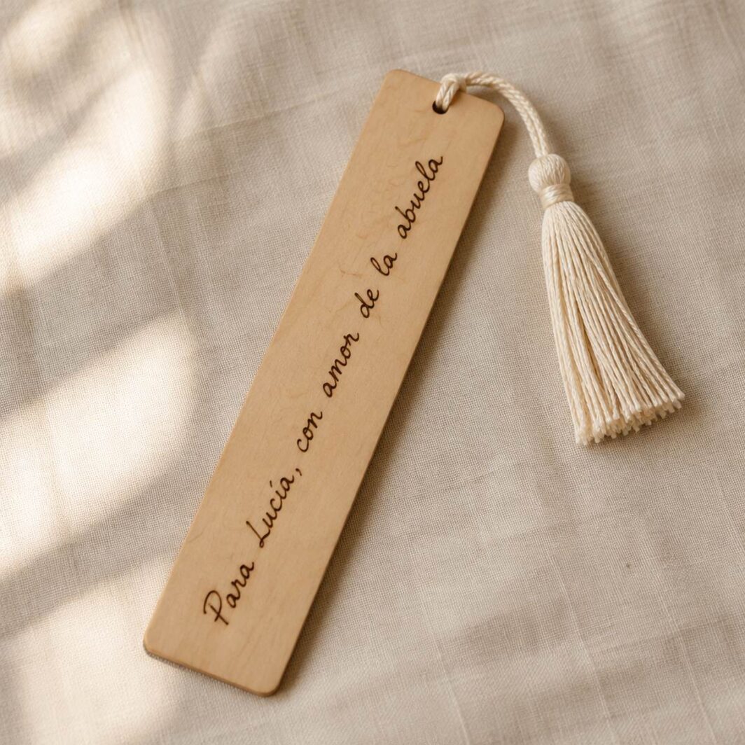 Marcapáginas de madera con borla y la dedicatoria manuscrita «Para Lucía, con amor de la abuela» pirograbada