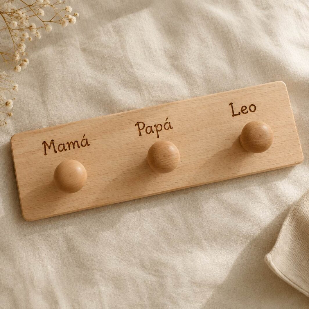 Perchero de madera con tres pomos y los nombres Mamá, Papá y Leo pirograbados sobre cada pomo
